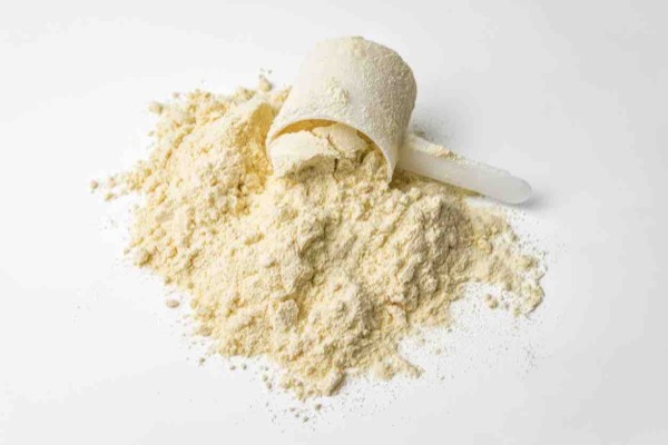 A scoop of Advanced Body Foods herbal superfood powder — loose powder, not a pill or capsule